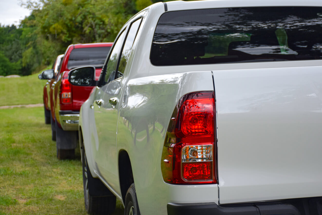 A line-up of Toyota pick-up trucks on grass.