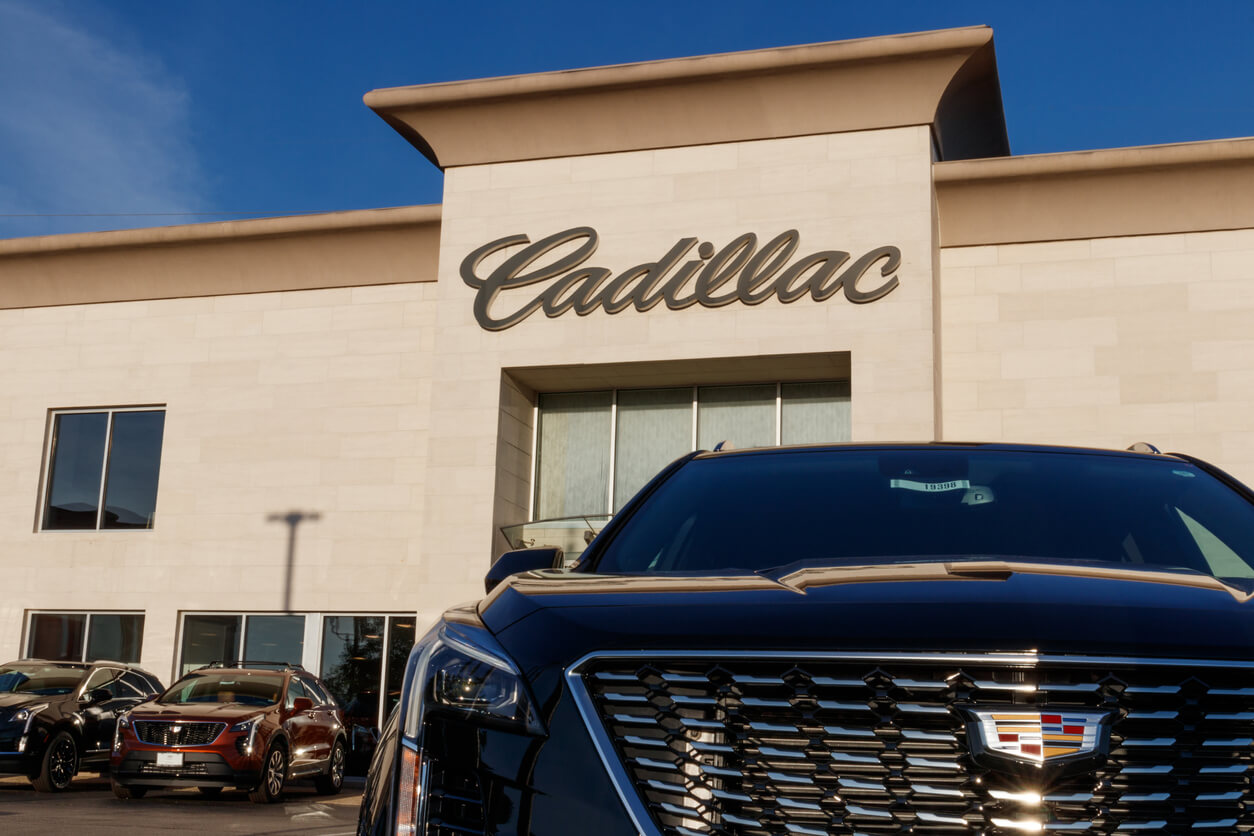Cadillac Escalade in front of Cadillac dealership.