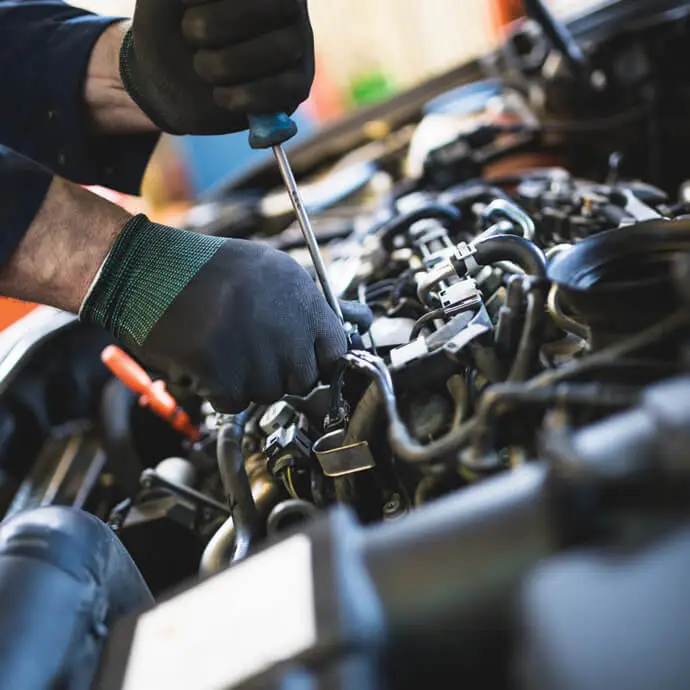 Mechanic works on car engine